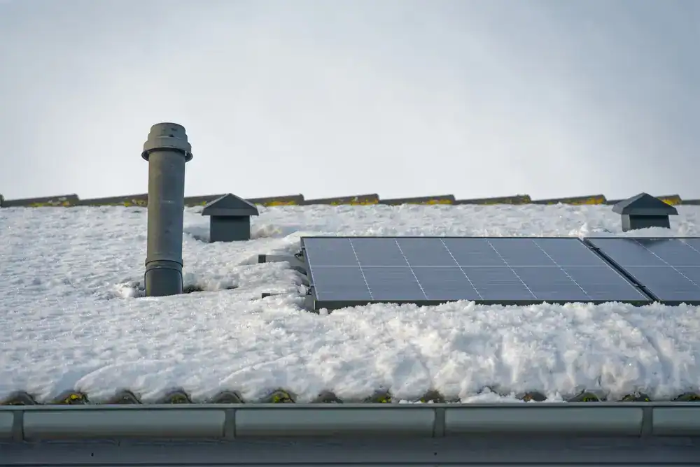 Solar panels on a roof with snow.